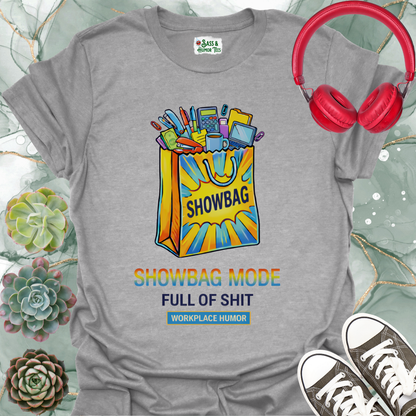 A funny workplace humor tee featuring the phrase “Showbag Mode: Full of Shit.”